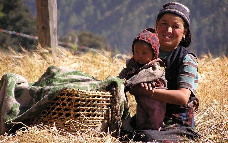 woman and child in rye field on the Manaslu Circuit Trek